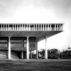 an architectural building with columns and balconies on the top floor is shown in black and white