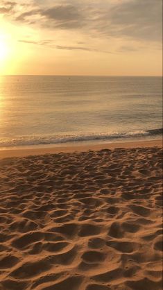 the sun is setting over the ocean and beach