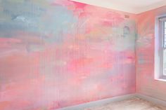 an empty room with pink and blue paint on the walls