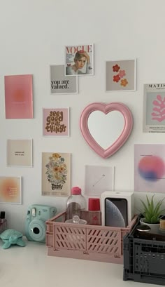 a white desk topped with lots of different types of art and decor on the wall