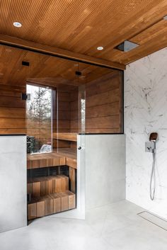 a bathroom with a wooden ceiling and white tile flooring next to a walk in shower