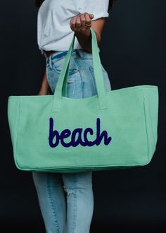 You'll be ready for the beach with this new bag! Our new colorful tote collection will have you vacation ready!  Mint green tote bag Navy "beach" textured text on the front Measures 11" x 20" x 6" Designed in the U.S.A. Produced in India.  100% Cotton Lining: 100% Polyester Large Capacity Weekender Bag For Beach, Summer Accessories Jewelry, Vacation Tote Bag, Spring Tote, Summer Tote Bag, Blouses Vintage, Tote Beach Bag, Green Tote Bag, Summer Tote Bags