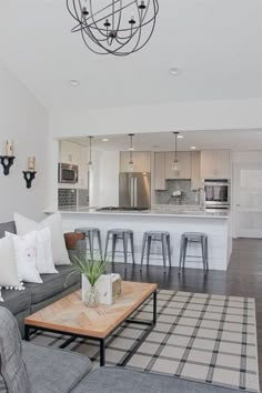 a living room filled with furniture next to a kitchen