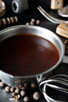 a pot filled with liquid sitting on top of a table next to kitchen utensils