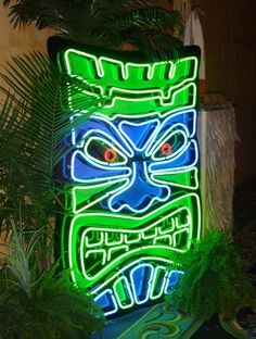 a green and blue tiki mask lit up in the dark