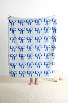 a person standing in front of a towel with blue bows on it