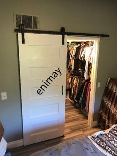 a bedroom with a bed, closet and white sliding barn door that opens to the other side