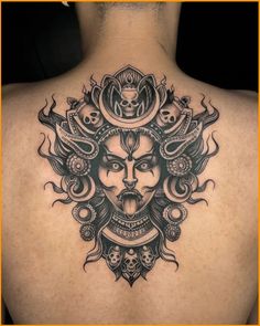 the back of a man's neck with an intricate tattoo design on his chest