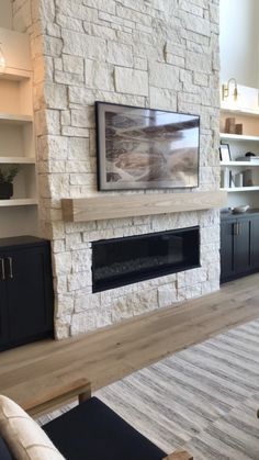 a living room with a large stone fireplace and built - in entertainment center on the wall