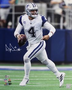 an autographed football player is running with the ball in his hand and wearing a helmet