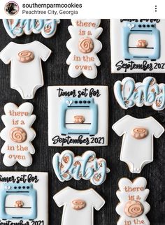 cookies decorated with baby ones and other items are displayed on a black tableclothed surface