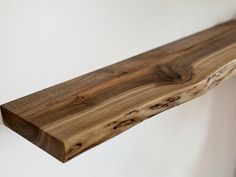 a wooden shelf sitting on top of a white wall