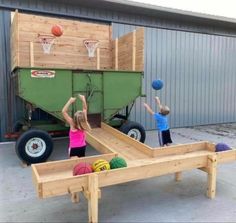 two children playing basketball in front of a green truck