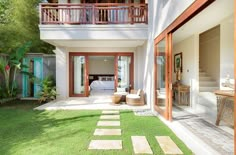 a house that has grass in front of it and stairs leading to the second floor