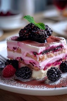 a piece of cake on a plate with berries and powdered sugar around the edges