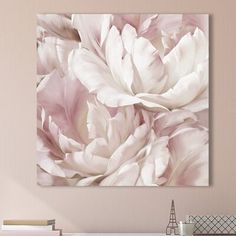 a white and pink flower on a wall above a desk