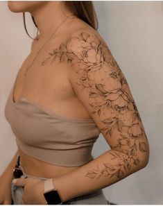 a woman's arm with flowers on it, and the top half of her body covered in tattoos