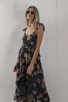 Black and rose floral midi dress. Held by thin adjustable straps with a ruffle detail. Elastic waist and back tied closure. Material: 70% Rayon, 30% Polyester. Sizing: Small: US Size 0-2 Medium: US Size 4-6 Large: US Size 8-10 Model Measurements: Height: 5’11” Chest: 32” Waist: 26” Hips: 36” Wearing size small. Floral Midi Dress, Model Measurements, Elastic Waist, Adjustable Straps, Size 4, Midi Dress, Elastic, Floral, How To Wear