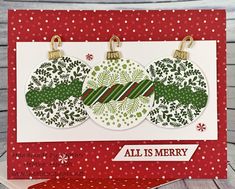 a christmas card with three ornaments hanging from the front, and merry lettering on the back