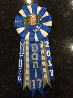 a blue and silver ribbon with a woman's face in the center on it