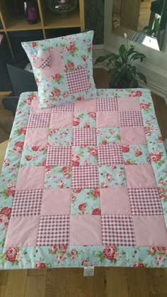 a bed with pink and white checkered bedspread, pillows and pillow cases