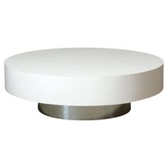 a white round table with metal base on a white background for use as a coffee table