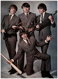 four men in suits and ties holding baseball bats