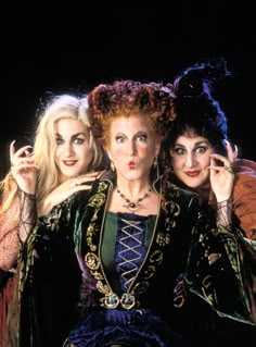 three women dressed in costumes posing for the camera