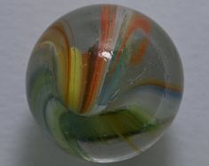 a glass ball sitting on top of a white table next to a black and orange object