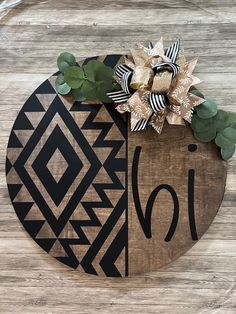 a wooden sign with a bow on top of it that says love and is decorated with greenery