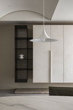 a modern kitchen with marble counter tops and white cabinets, along with a black shelf