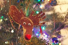 a close up of a christmas tree with a reindeer ornament hanging from it