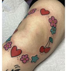 a woman's leg with flowers and hearts on it, while she is laying down