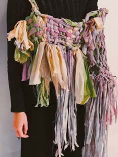 a woman is wearing a scarf made out of old scarves and other fabric pieces