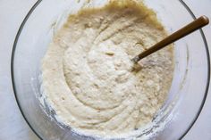 a glass bowl filled with batter on top of a table