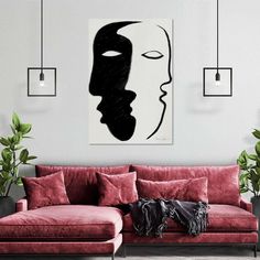 a living room with red couches and paintings hanging on the wall above it's head