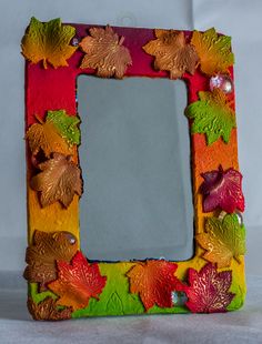 a multicolored frame with autumn leaves on it