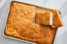 a loaf of bread sitting on top of a pan with slices cut out of it