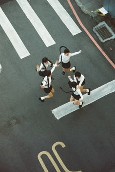 three women in black and white outfits are crossing the street