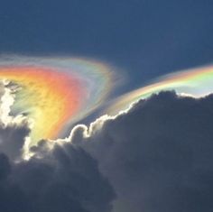 a rainbow in the sky with clouds around it