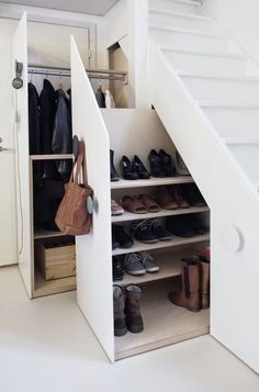 an open closet with shoes and purses in it