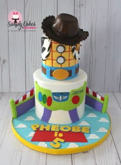 a three tiered cake is decorated with toy cars and hats on it's sides