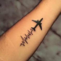 an airplane is flying through the air with a heartbeat tattoo on it's arm