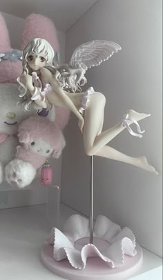 a white teddy bear sitting on top of a shelf next to a pink stuffed animal