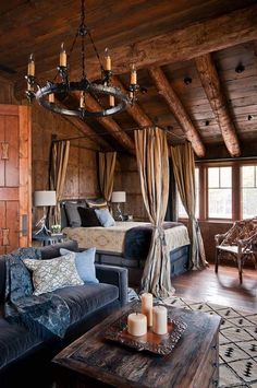 a living room filled with furniture and a chandelier hanging from the ceiling next to a bed