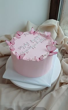 a pink birthday cake with butterflies on it