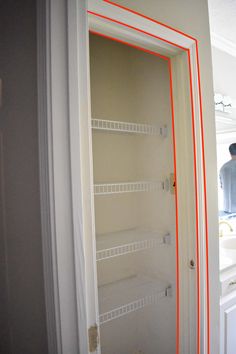 a man standing in front of a bathroom mirror with red lines on the wall next to it