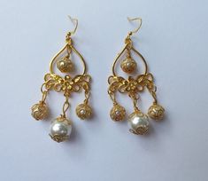 gold earrings pearls earrings Victorian earrings filigree Earrings Bohemian white pearls gold earrings vintage Antique chandelier earrings Beautiful Victorian filigree gold tone and glass white pearls earrings. Filigree earrings. Chandelier earrings . Dangle earrings. Drop earrings . Boho earrings. Bohemian earrings. Gold - tone and pearls earrings. Vintage style earrings. Baroque earrings. Antique style earrings. Bridal earrings. Wedding earrings. Royal style earrings.  Combine shipping options is available.  Material : gold tone ornaments beads, glass white pearls Length with hooks : 2.95 ( 7.5 cm) If you have any question, please contact me ! Thank you for visiting my shop ! If you have a RUSH ORDER and you want to pay for FAST SHIPPING by DHL - 3-5 business days is HERE :  https://www. Baroque Earrings, Victorian Filigree, Roman Jewelry, Victorian Earrings, Style Royal, Pearls Earrings, Earrings Chandelier, White Pearl Earring, Vintage Style Earrings