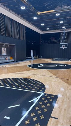 an indoor basketball court with wooden floors and black walls