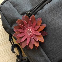 a flower is placed on the side of a piece of luggage that's attached to a chain